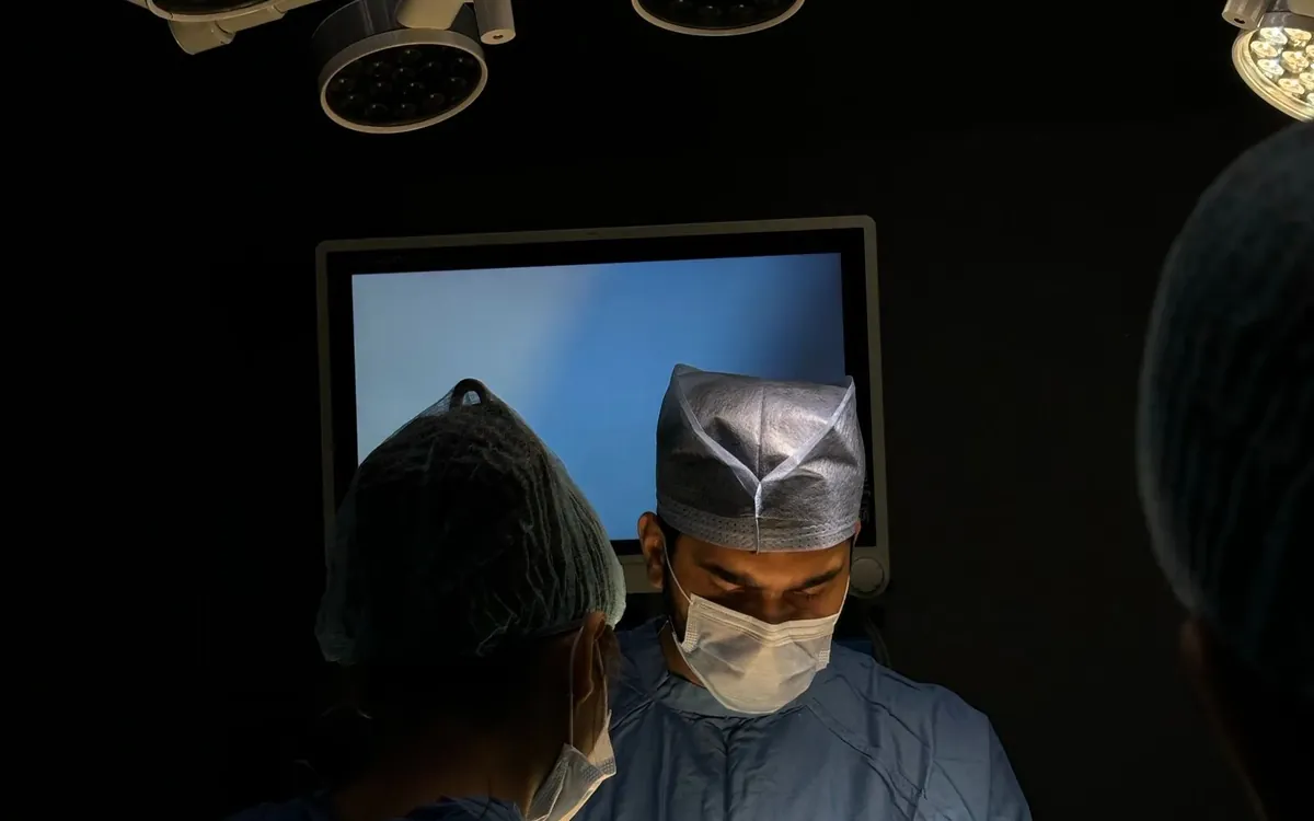 Aesthetic surgery team working under surgical lights in a modern operating room